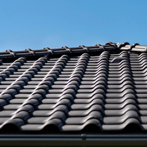 Couvreur au travail sur une toiture, vue d'ensemble